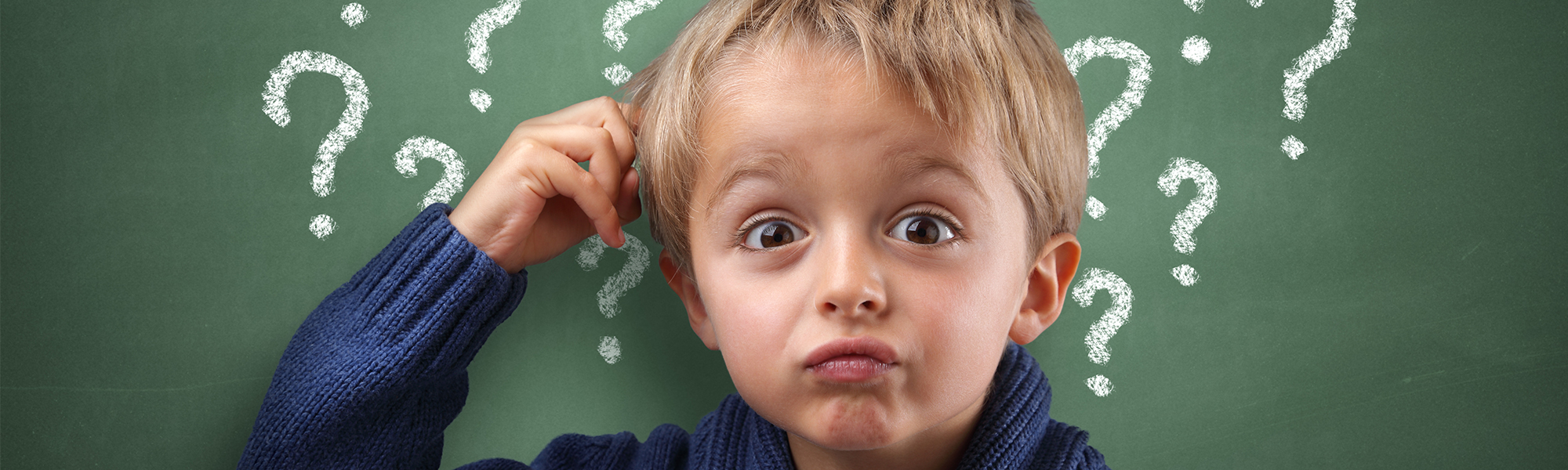 child scratching his head with question marks around him
